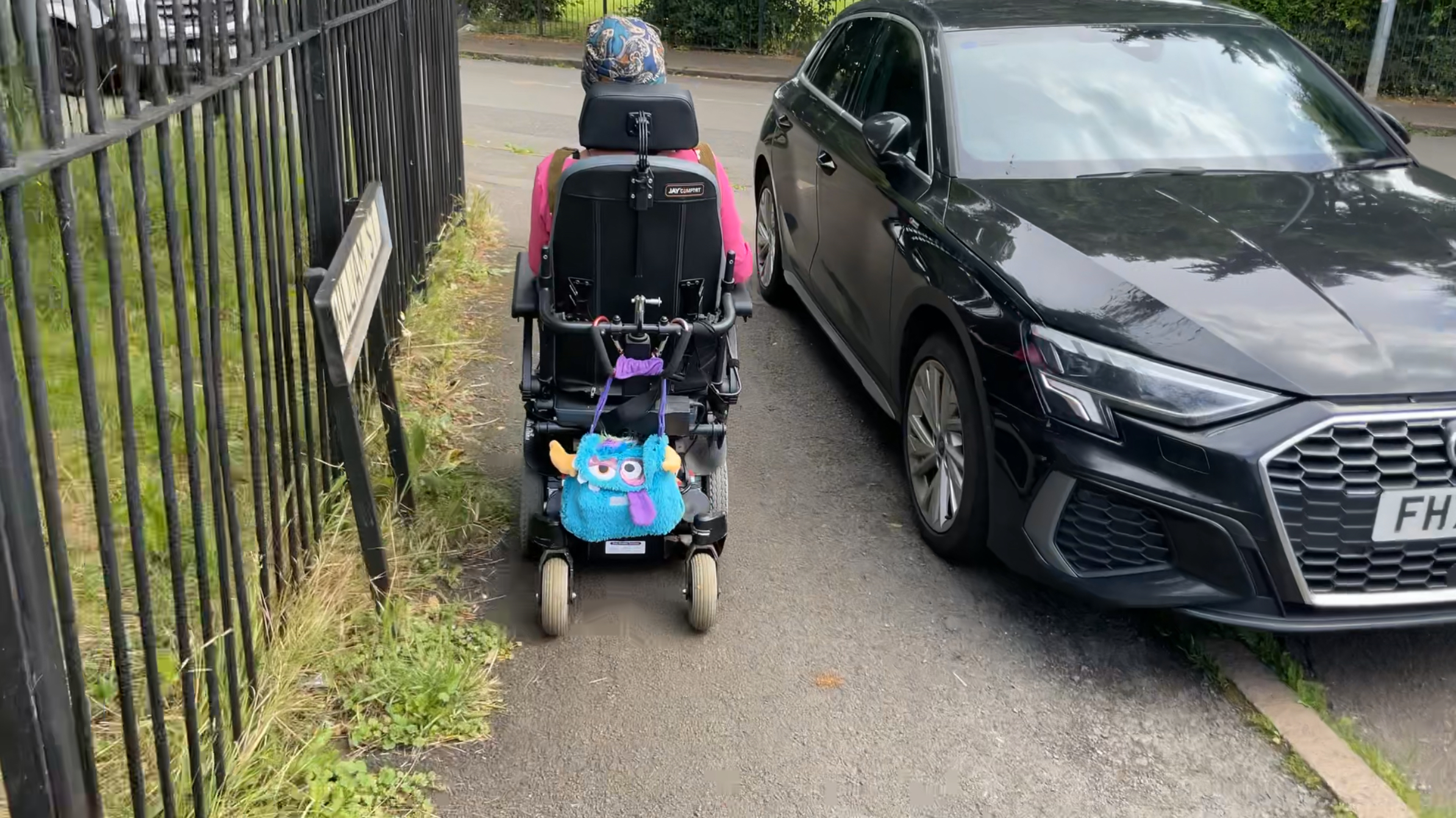 Power chair user with car on pavement