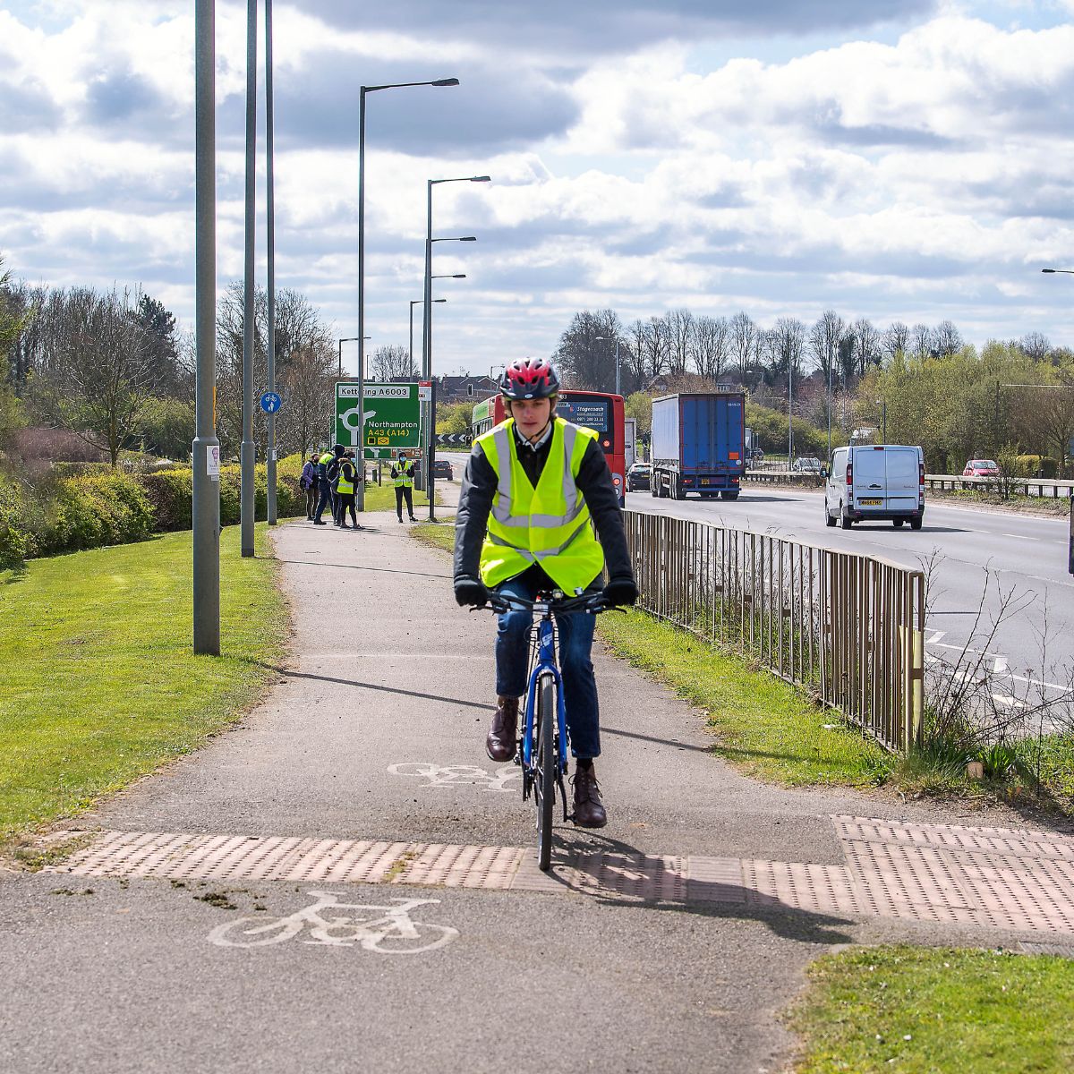 Cyclist on cycle lane, with sign in the background