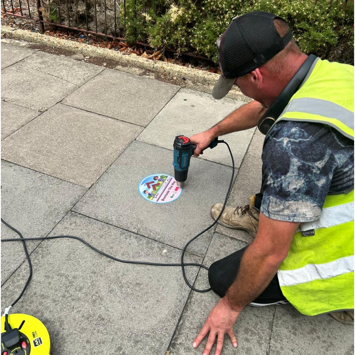 Ealing Pavement sticker being installed.