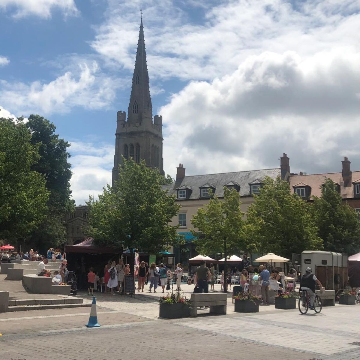 A bustling market, showing cyclist and pedestrians